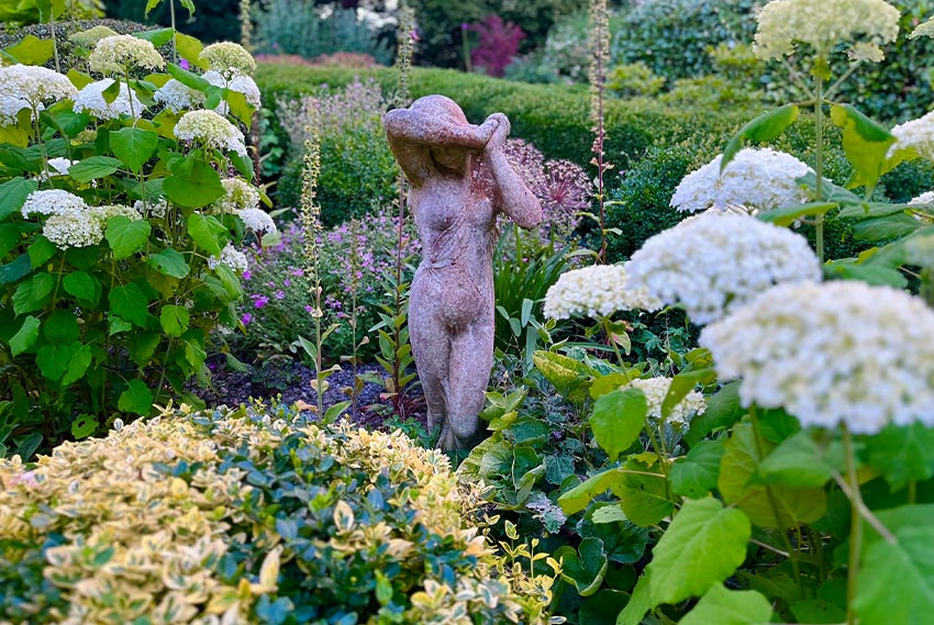 Statue of woman surrounded by flowers