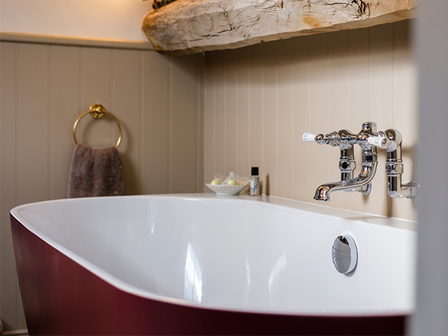 Red Bathtub with Towel in Background.