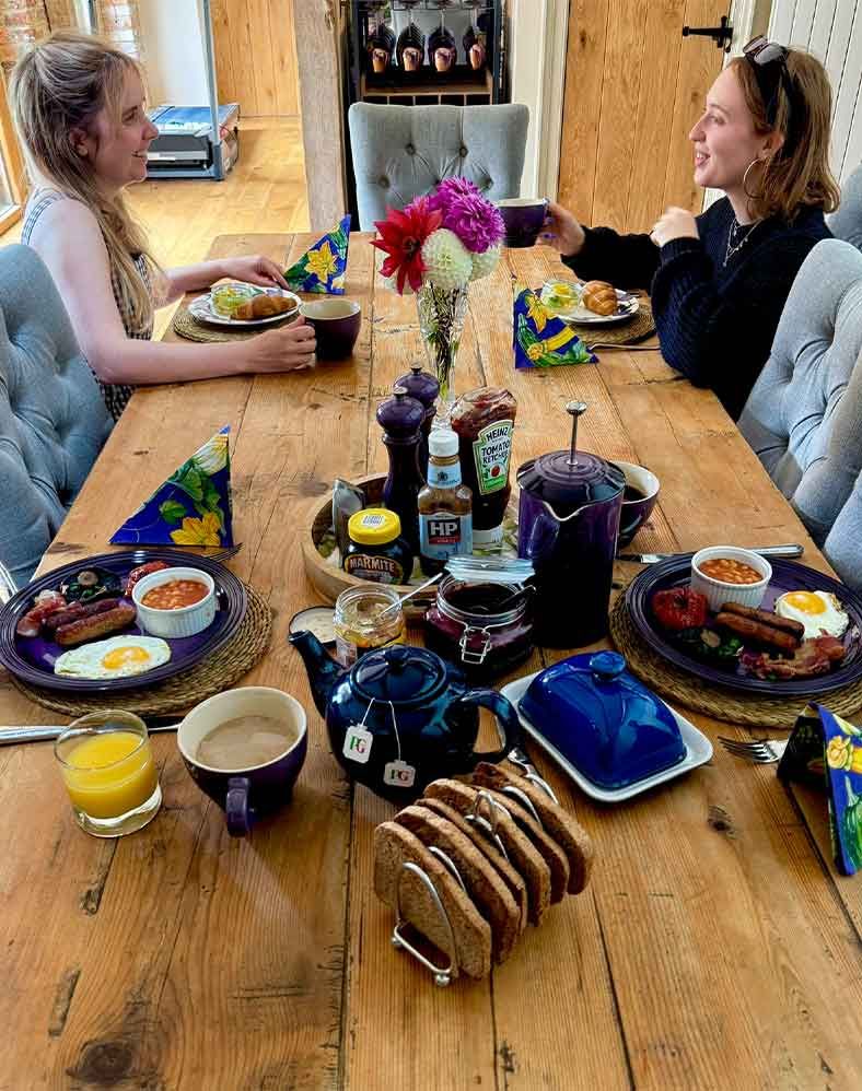 Guests Eating Breakfast and Chatting at Dining Table