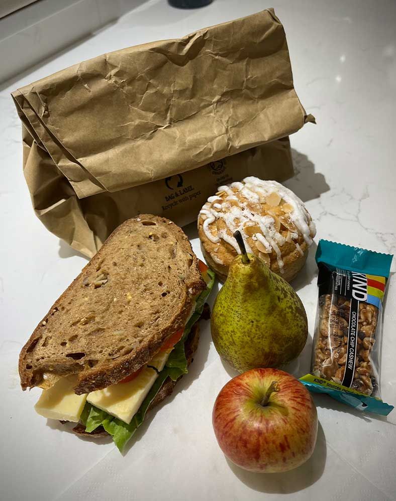 Picture of Packed Lunch with a Sandwich, Pear, Apple, Cake & Energy Bar